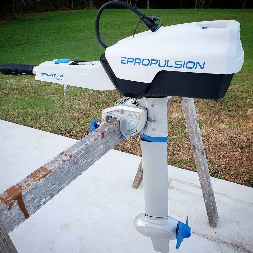 EPropulsion Spirit 1.0 Plus electric outboard motor resting on a wooden platform, showcasing its compact design. 