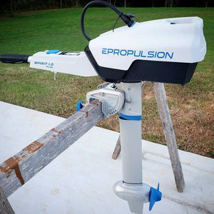 EPropulsion Spirit 1.0 Plus electric outboard motor resting on a wooden platform, showcasing its compact design. 
