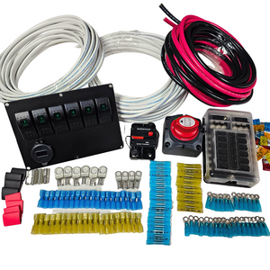 Electrical kit with black switch panel, red battery switch, fuse box, coiled red/black and white wires, and various blue, yellow, and silver connectors.