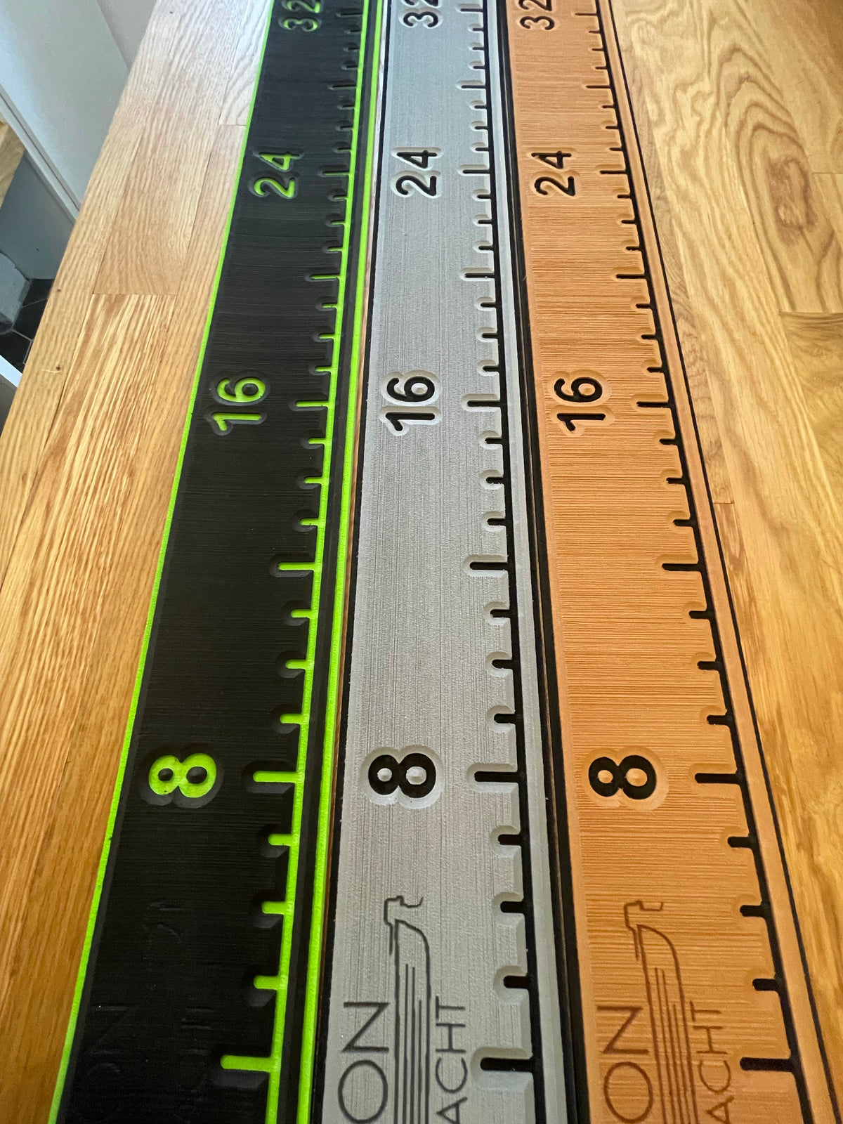 Three 38 1/4" x 4" fish ruler pads in black, grey, and tan with green, black, and black markings.