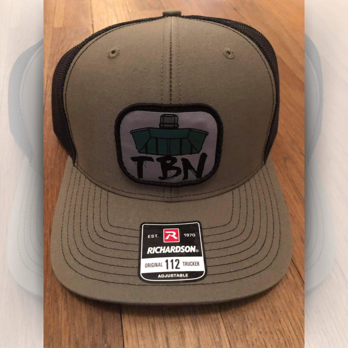 Olive green Richardson 112 trucker hat with black mesh back and embroidered TBN Jon Boat patch.
