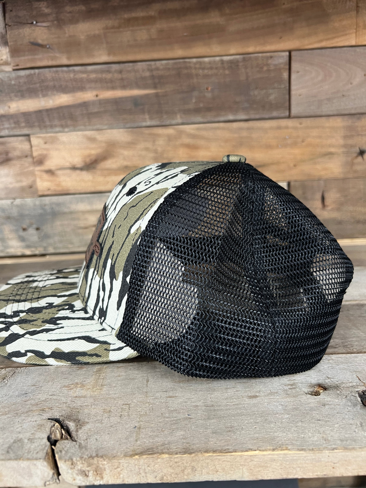 Camo "Tiny Boat Big Deck" trucker hat with black mesh back and flat brim.