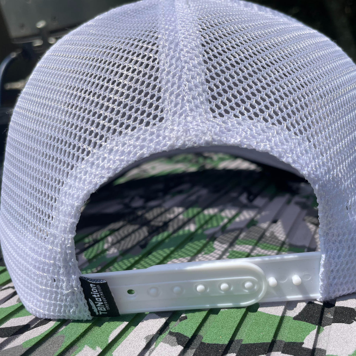 White mesh trucker hat with adjustable snapback closure and "TBNation" tag.