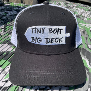 Black and white trucker hat with "Tiny Boat Big Deck" embroidered on a white patch.