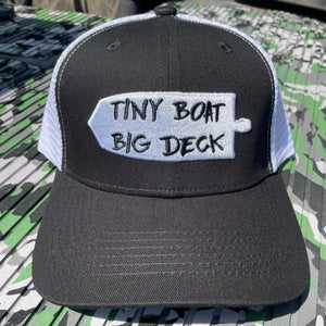Black and white trucker hat with "Tiny Boat Big Deck" embroidered on a white patch.