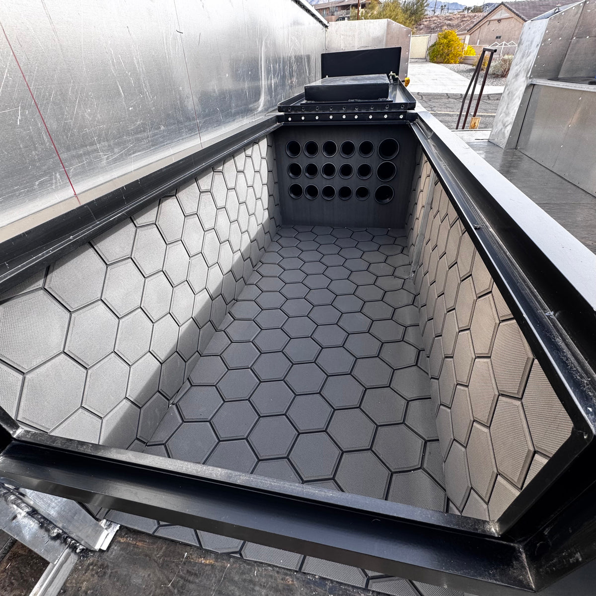 Dark gray Hydro Turf Pro Series EVA foam mat with a textured honeycomb pattern lining a boat compartment.