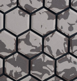 Hexagonal wall tiles with a gray and black camouflage pattern and a textured surface.