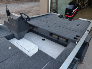 Gray carpeted boat deck with a black steering console, storage compartments, and a Mercury outboard motor.