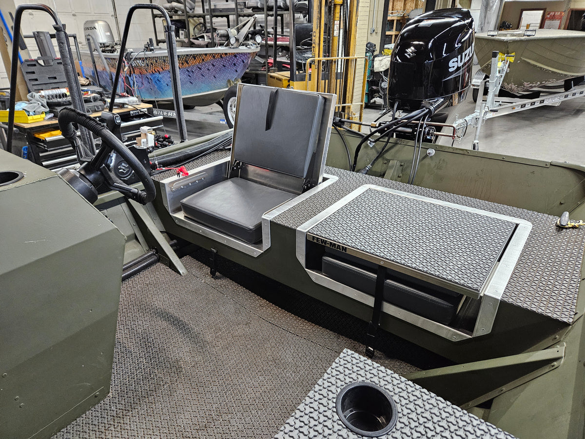 Green boat interior with a black vinyl JumpSeat in the upright position and a matching stowed seat.