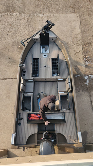 Overhead view of a person installing a black flip-up stowable JumpSeat in a boat's deck.