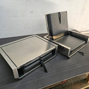 Two stainless steel Few-Man JumpSeats, one closed and one open with charcoal vinyl cushions.
