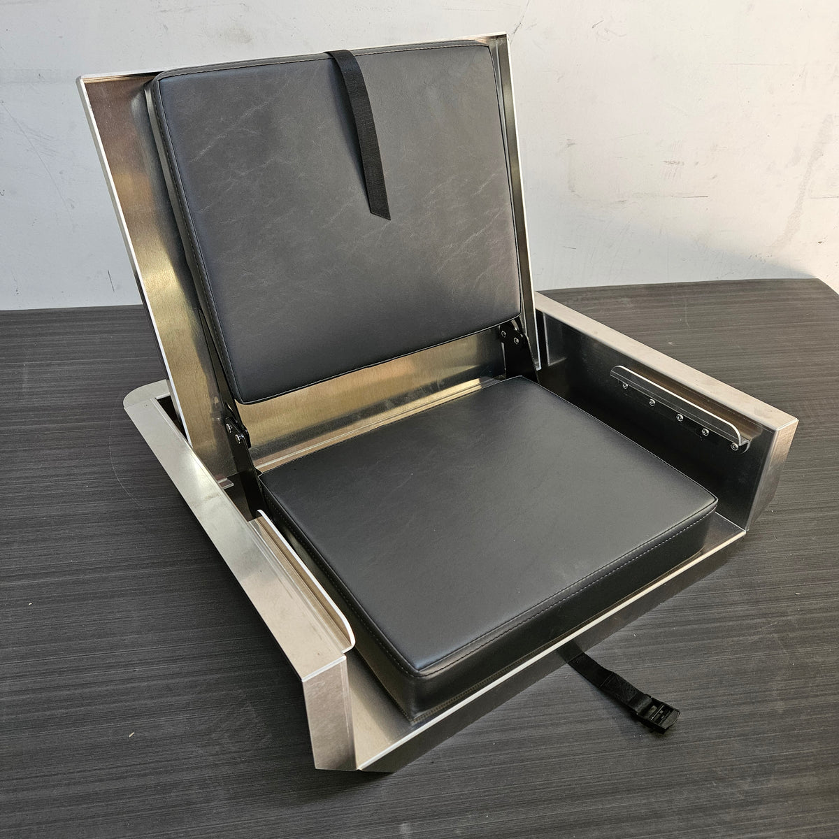 Silver aluminum JumpSeat with black vinyl cushions, open and ready for use.