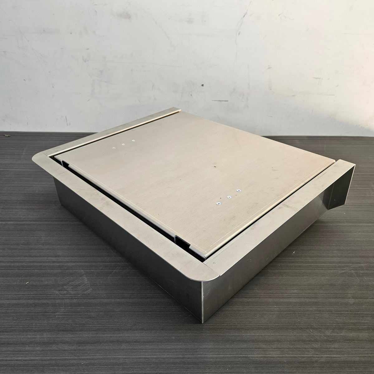 Silver stainless steel JumpSeat, a flip-up stowable boat seat with a flat lid, designed for DIY drop-in installation.