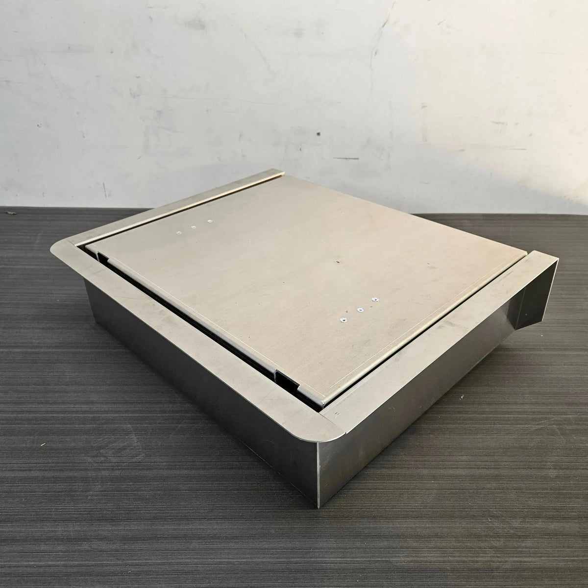 Silver stainless steel JumpSeat, a flip-up stowable boat seat with a flat lid, designed for DIY drop-in installation.