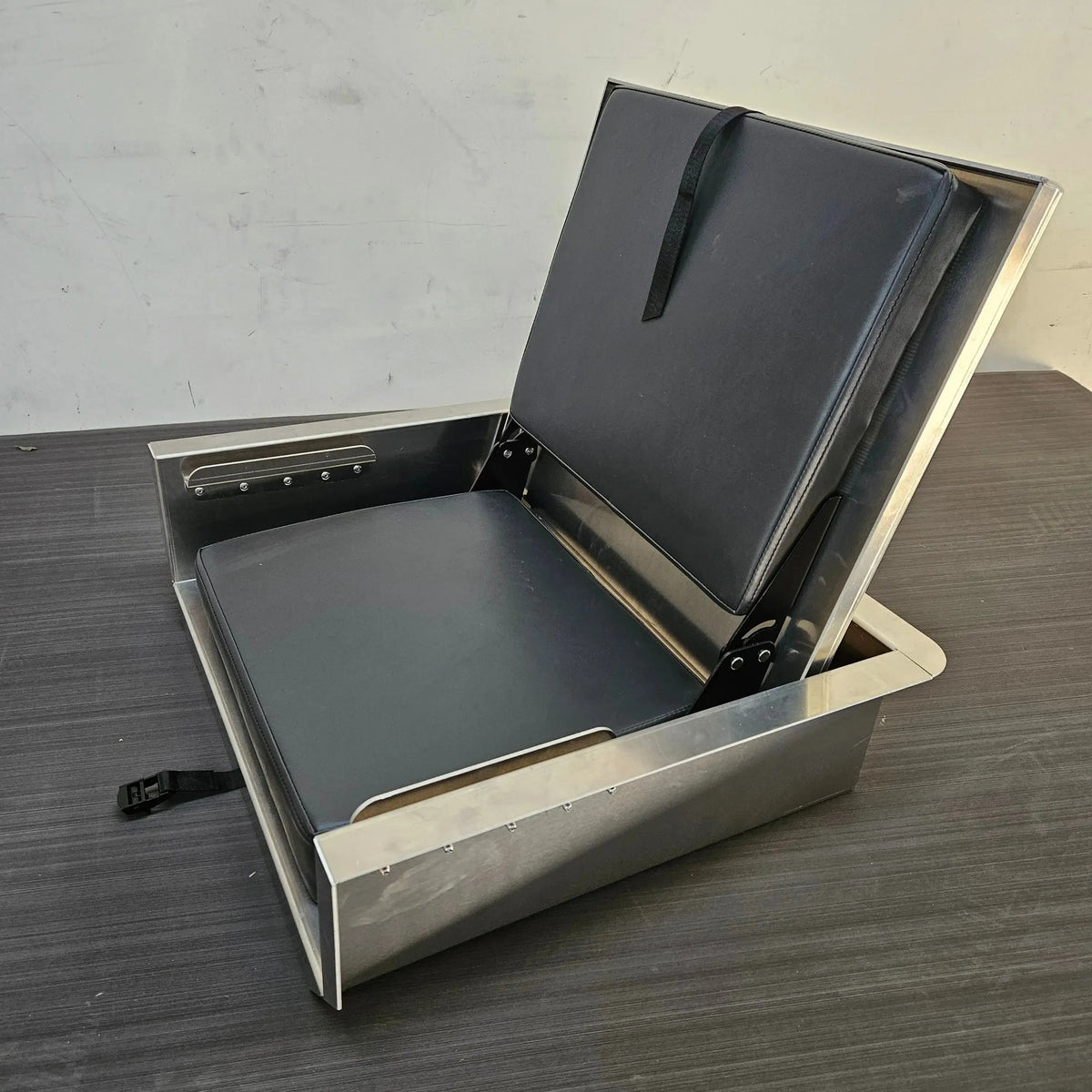 Silver aluminum flip-up stowable boat seat with black vinyl cushions, open and ready for use.