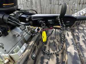 Braided black and gray paracord key lanyard with a yellow float and kill switch attached to a boat motor.