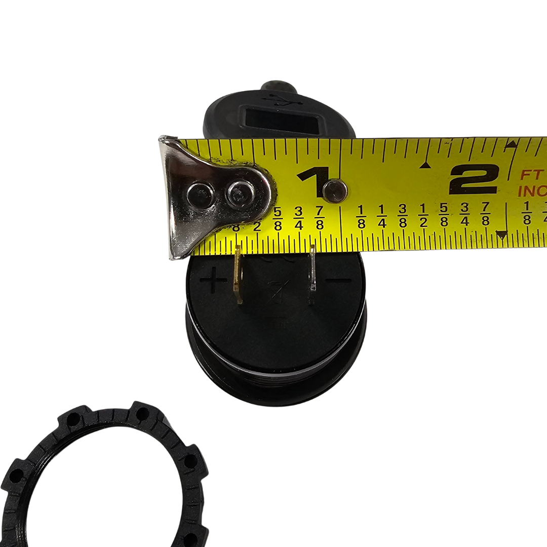 Black LED voltmeter with USB ports, shown with a measuring tape for size.