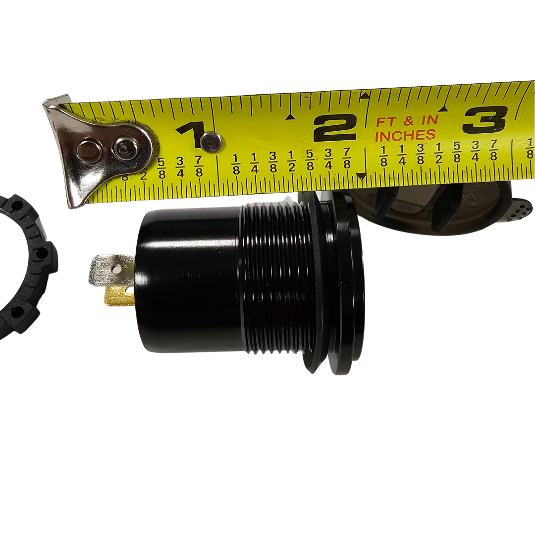 Black LED voltmeter with gold terminals, shown next to a yellow tape measure for size reference.