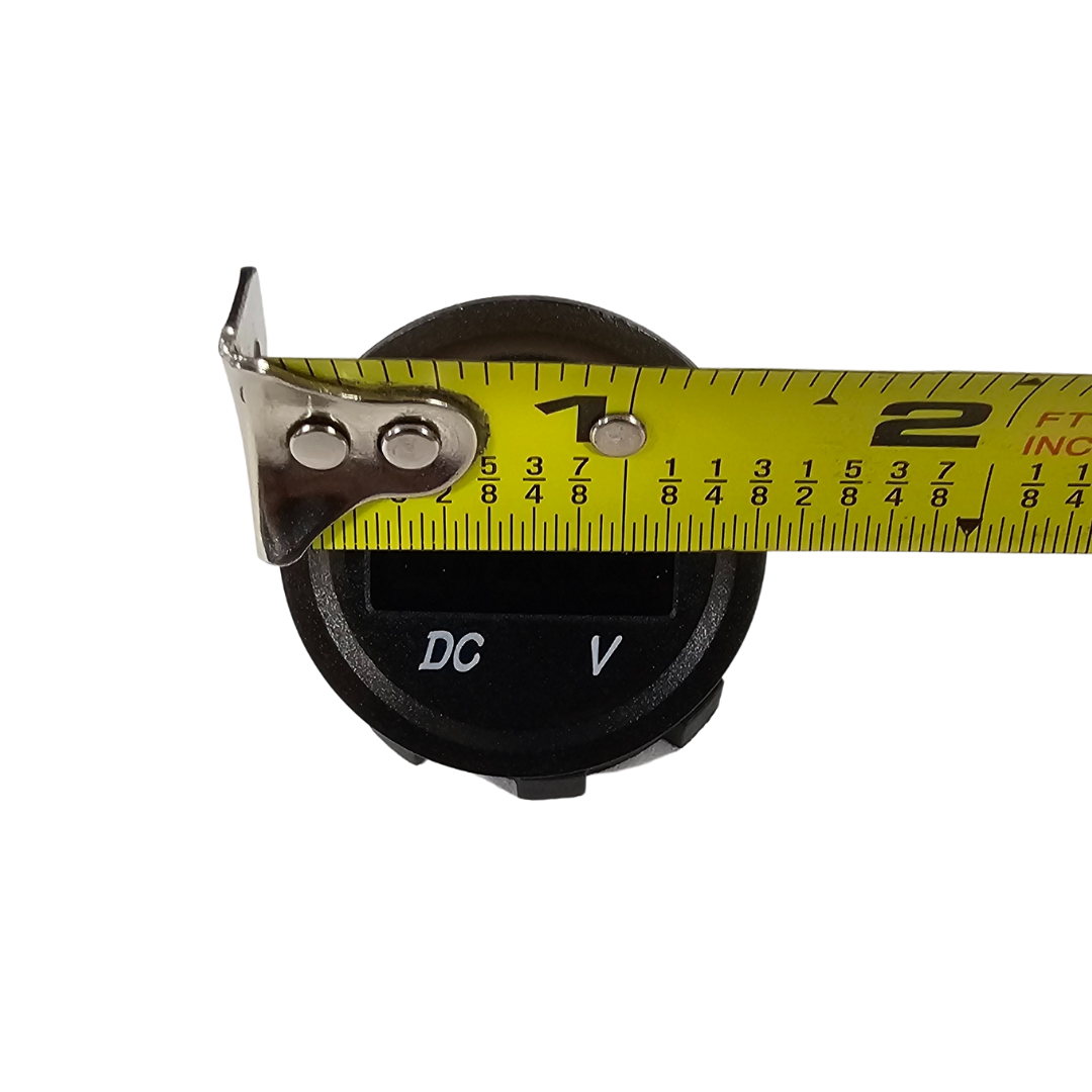 Black round LED voltmeter with "DC V" text, measured by a yellow tape measure.