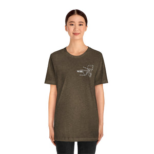 Woman wearing a brown MERC Tiller tee with a white outline graphic of a boat motor on the left chest.