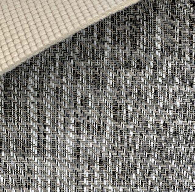 Close-up of MariDeck Ultra Premium Vinyl Boat Flooring, showing the woven texture in gray and black, with a beige padded backing.