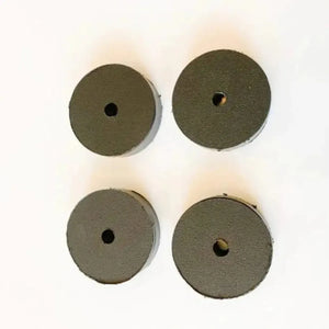 Four dark gray round UHMW motor clamp spacers, 1-inch thick, with a central hole.