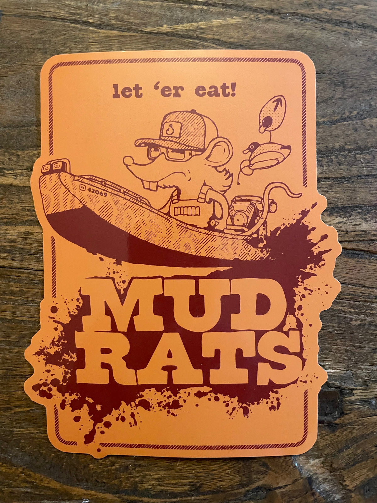 Orange Mud Rats decal with a cartoon rat in a boat, "let 'er eat!" text, and a splash design.