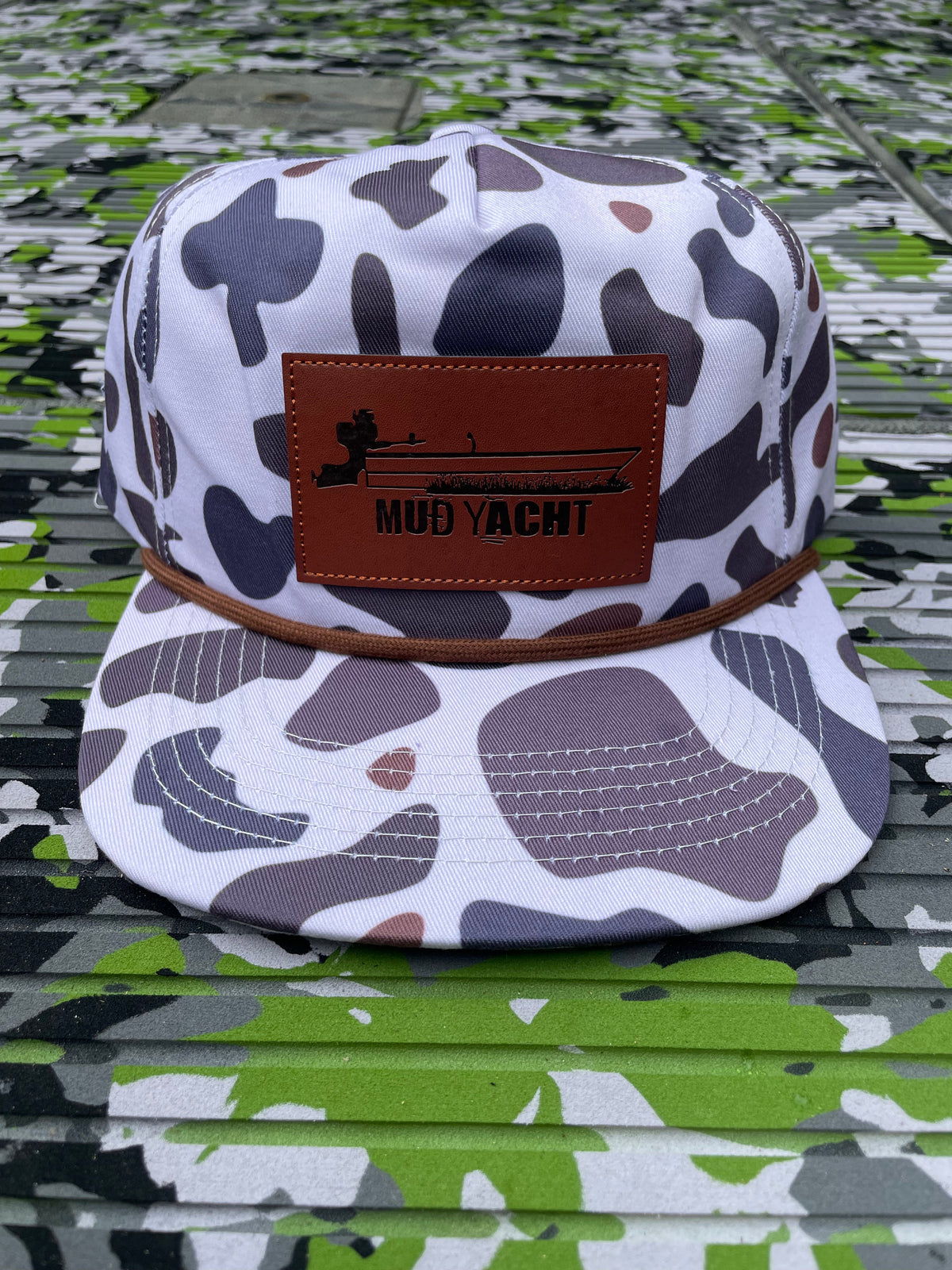 White camo rope hat with a brown leather "Mud Yacht" patch featuring a boat silhouette.
