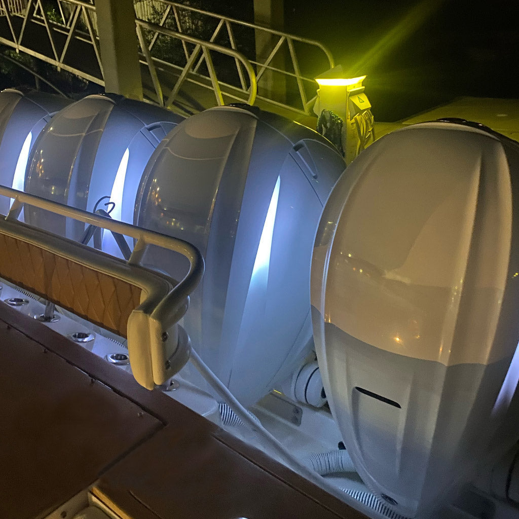 White Mercury 450 outboard engines with bright white Neon Flex LED strips illuminating the cowlings at night.