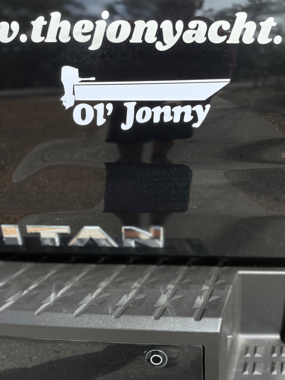 White 10" Ol' Jonny vinyl decal featuring a boat design, applied to a dark vehicle.