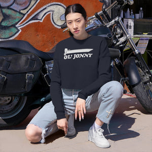 Woman in black Ol' Jonny cropped sweatshirt, light wash ripped jeans, and white sneakers by a motorcycle.