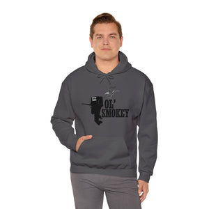 Man wearing a charcoal grey Ol' Smokey Hoodie with a black 2-stroke engine graphic and front pocket.