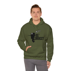 Man in an olive green Ol' Smokey Hoodie with a black two-stroke engine graphic, front pocket.