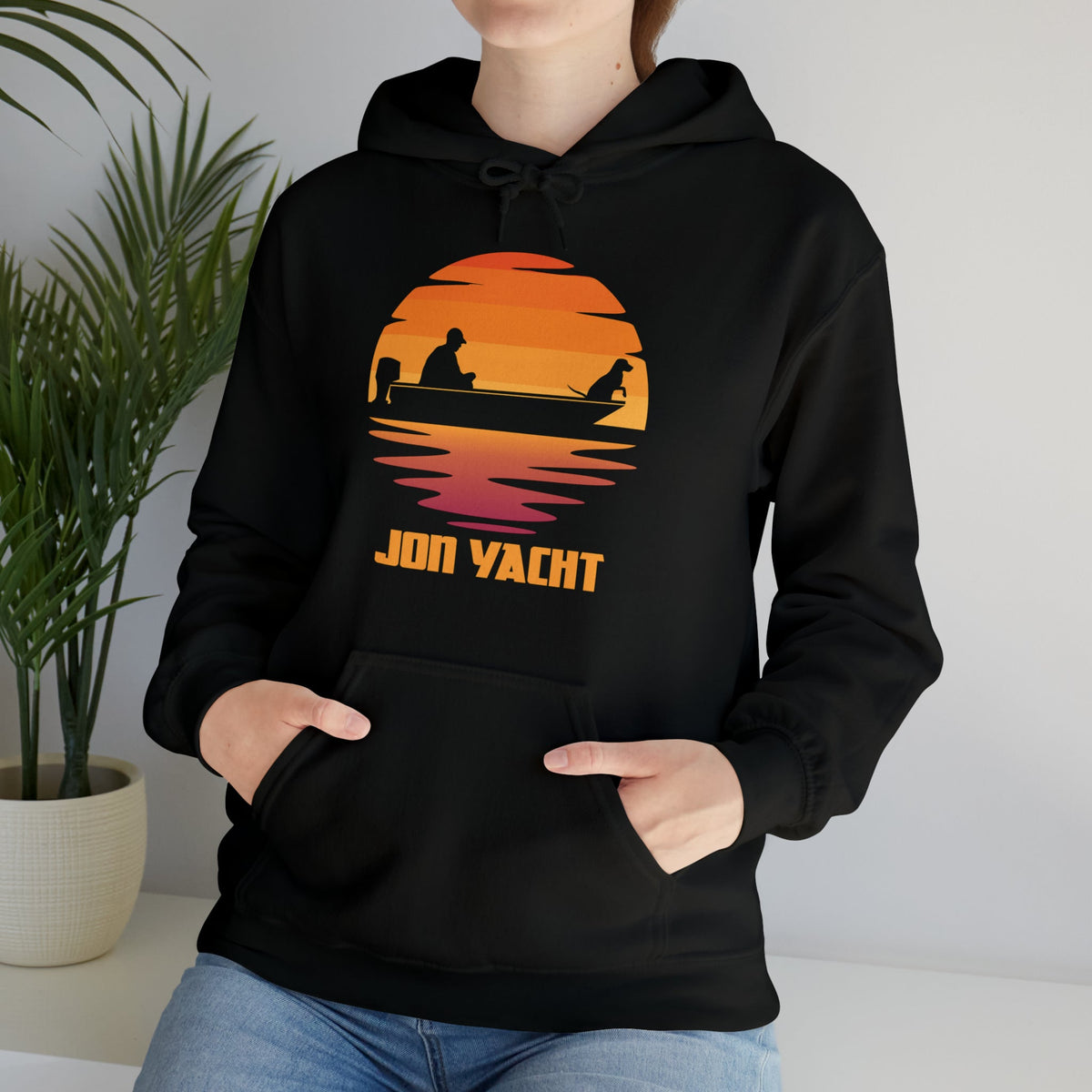Black Ol Yeller hoodie with a sunset graphic of a person and dog in a boat, "JON YACHT" text.