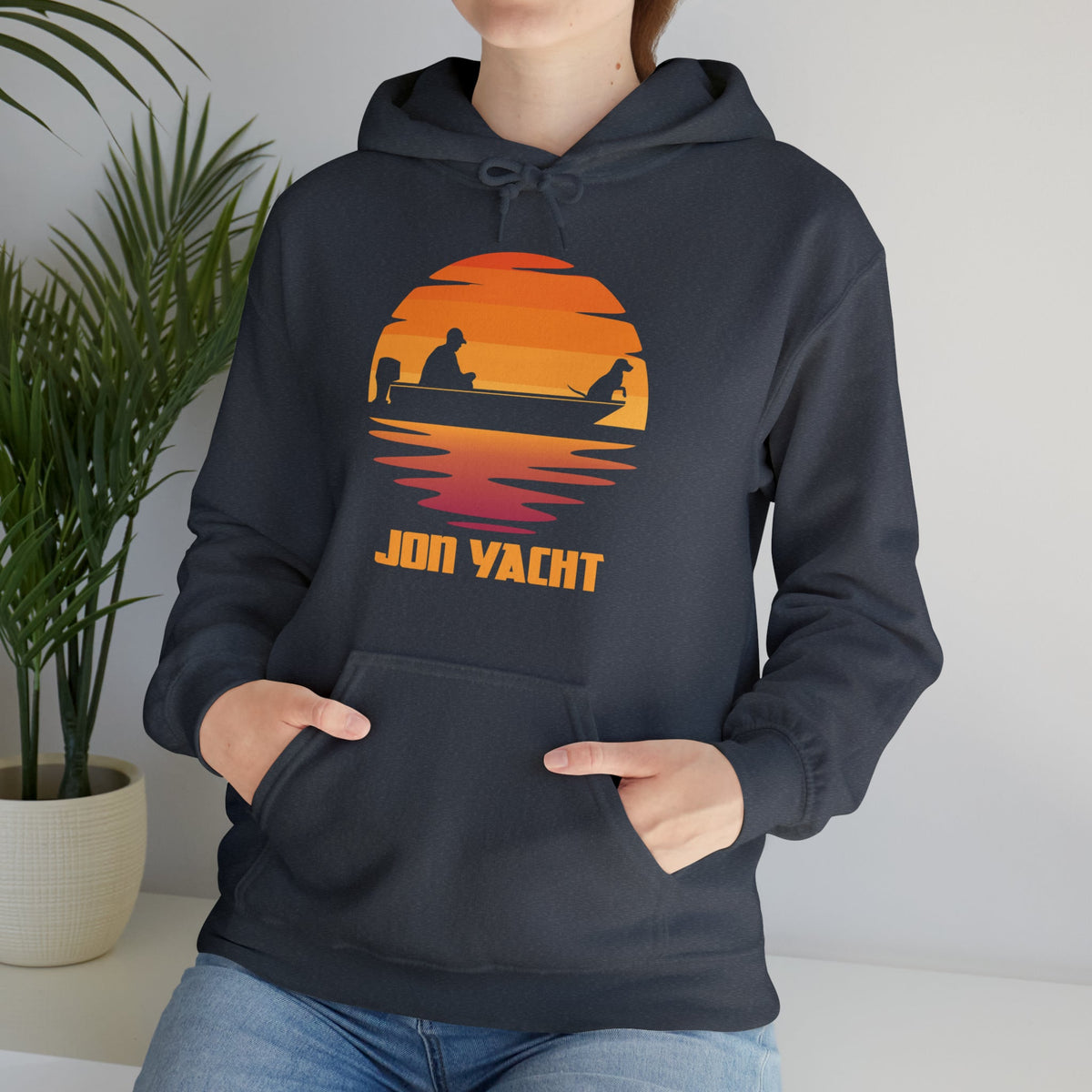 Dark gray hoodie with a vibrant orange and red sunset graphic featuring a person and dog in a boat.