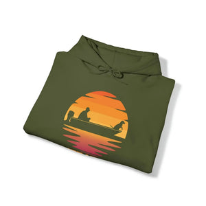 Olive green hoodie with a sunset graphic featuring a person and dog in a boat.