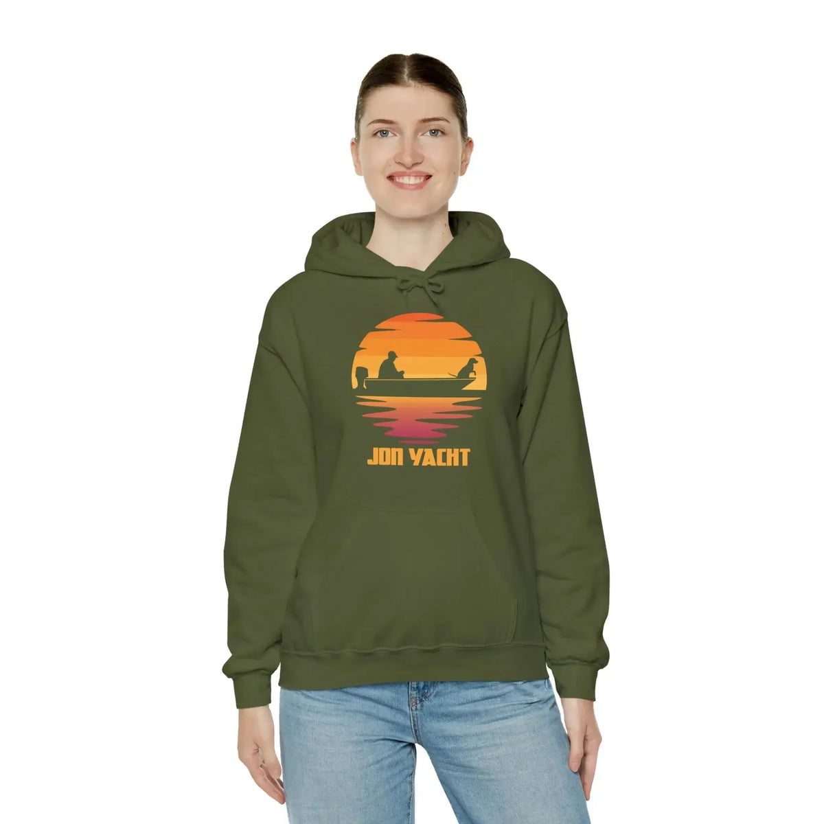 Woman wearing an olive green "Ol Yeller Hoodie" with a sunset boat graphic and "JON YACHT" text.