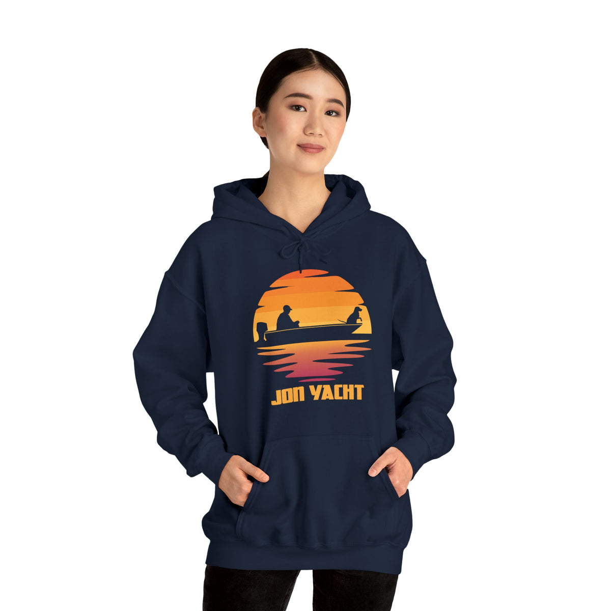 Woman wearing a navy blue "Ol Yeller Hoodie" with a sunset boat graphic and "JON YACHT" text.