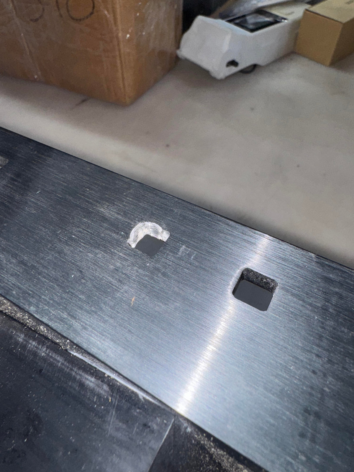 Close-up of a used black anodized aluminum Panther 4-Stroke Bracket with two mounting holes.