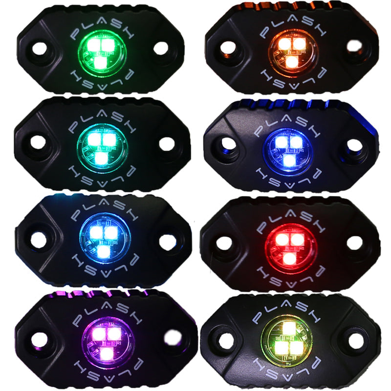 Eight black PlashLights RGB rock lights displaying various colors: green, orange, aqua, blue, light blue, red, purple, and lime green.