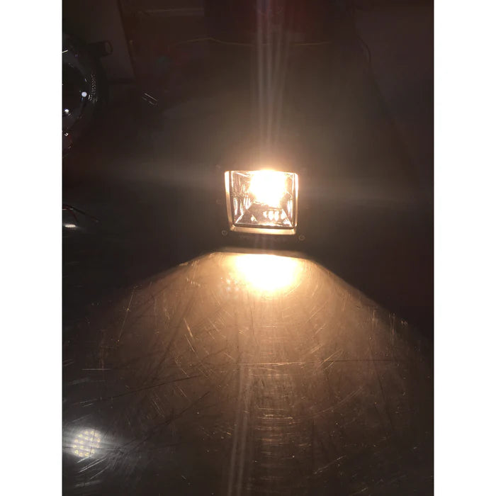 PlashLights 2" 40W warm white fishing cube light illuminated, casting a bright glow on a dark surface.
