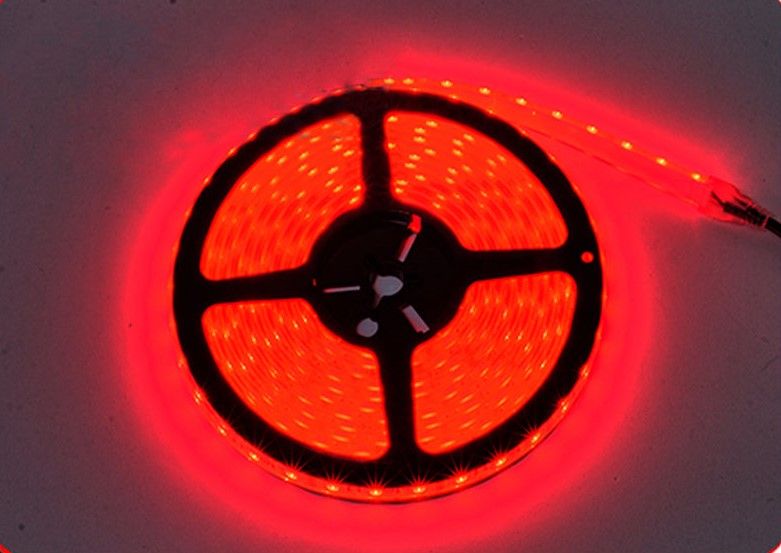 Spool of PlashLights 16ft RGB waterproof flexible LED light strip, glowing bright red.