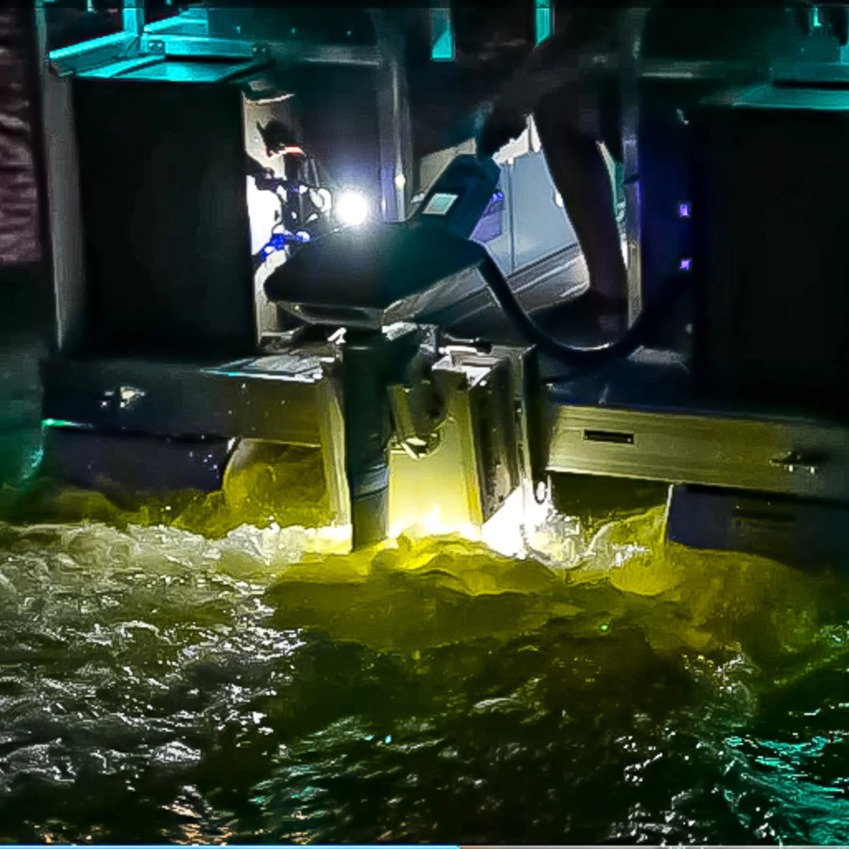 Plashlights EPIK underwater transom light illuminating murky water with a bright yellow-green glow.