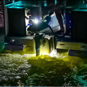 Plashlights EPIK underwater transom light illuminating murky water with a bright yellow-green glow.