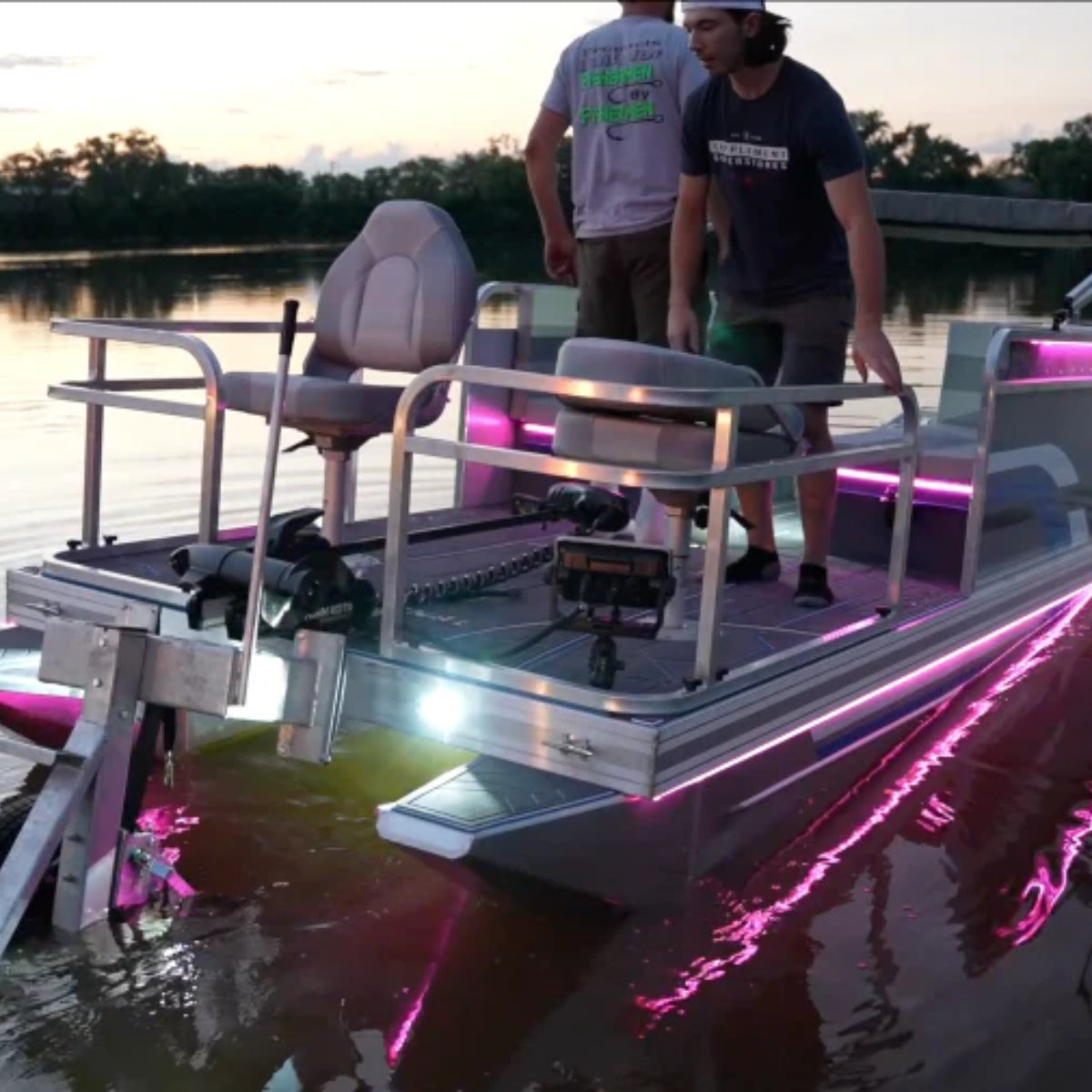 Pontoon boat with bright pink and white Plashlights EPIK LED underwater transom lights illuminating the water.
