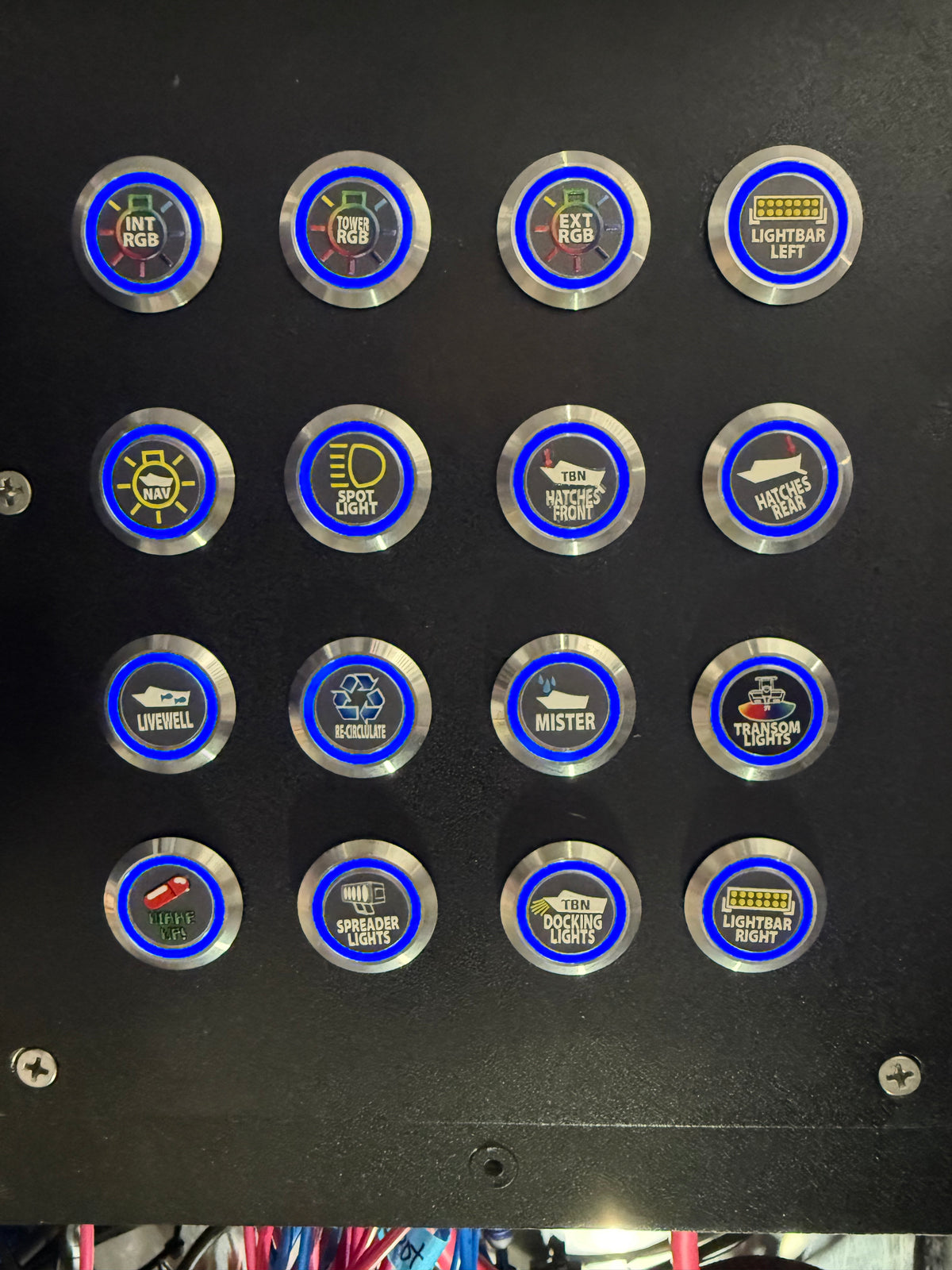Plashlights REVERT 22mm marine switches with blue LED rings, custom labels, and metal bodies on a black panel.