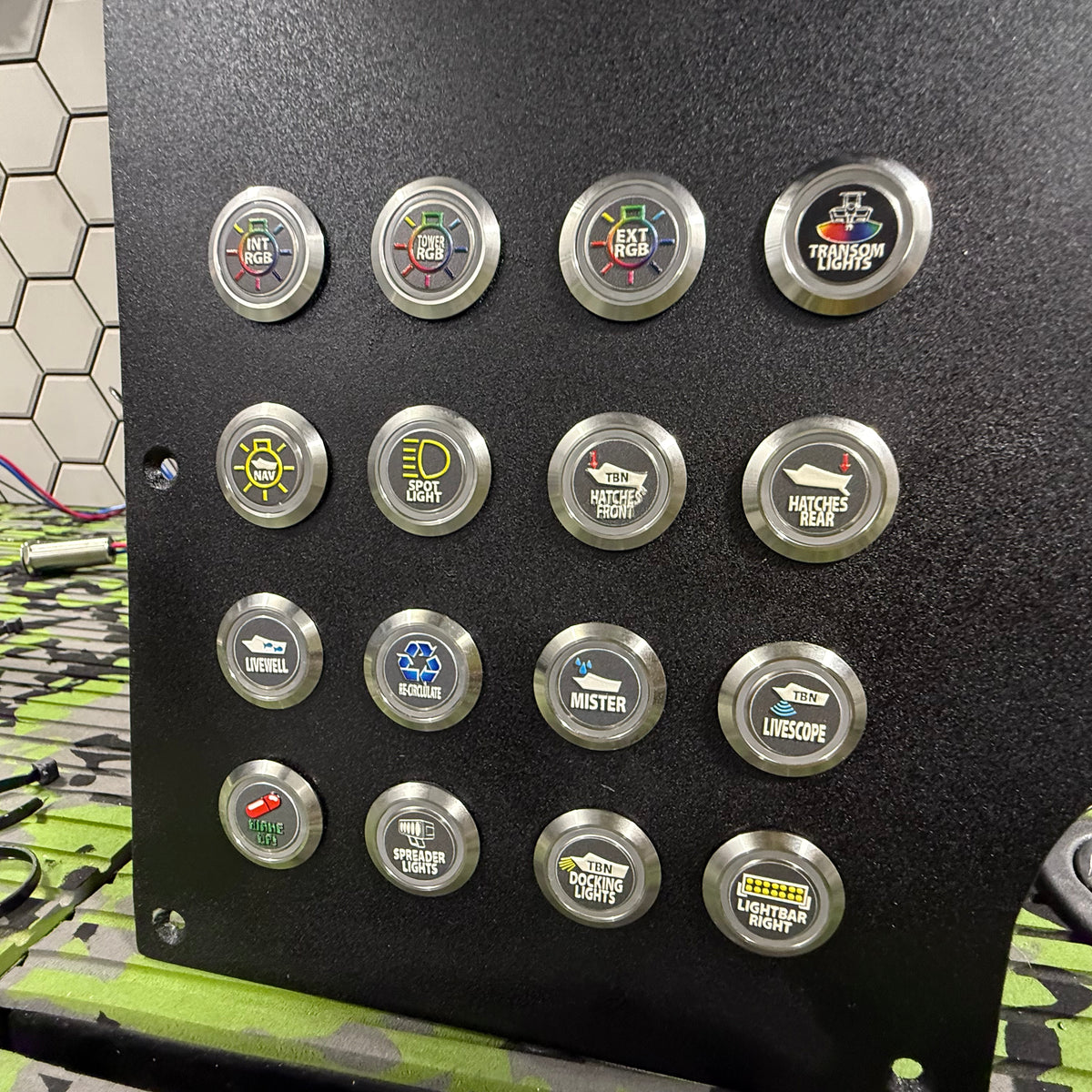 Black panel with sixteen 22mm round, silver metal Plashlights REVERT boat switches, each with a custom icon.