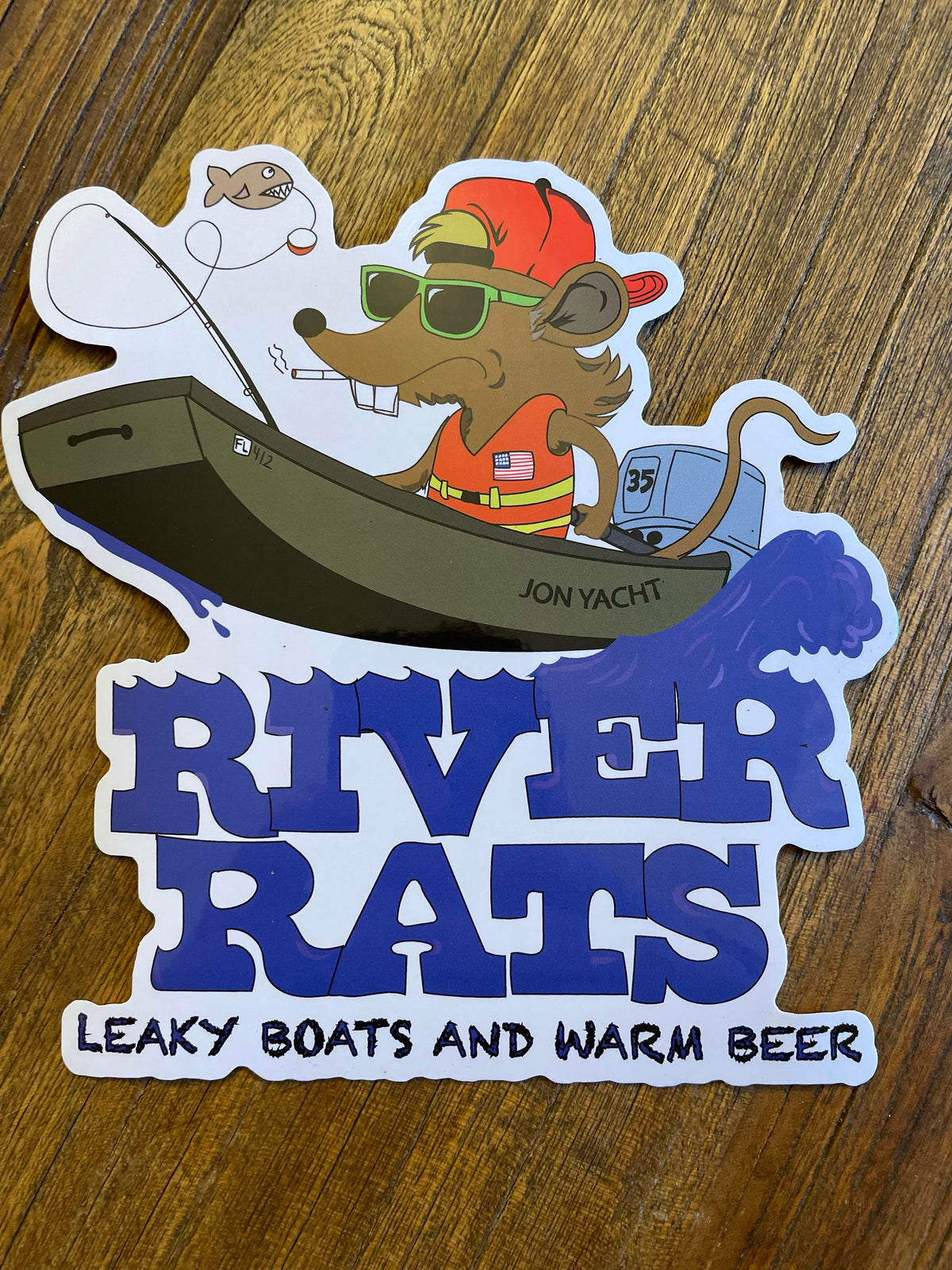 Cartoon rat in a boat with "River Rats" text, "Leaky Boats and Warm Beer" slogan.