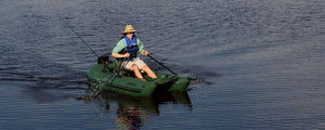 Hunter Green Sea Eagle 285 Frameless Pontoon Boat with a person rowing, fishing on calm water.