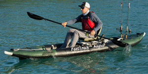 Man paddling a green and black Sea Eagle 385fta FastTrack Angler inflatable kayak with fishing rods.